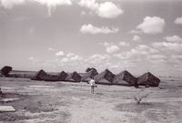Aspiration row of huts with woman walking